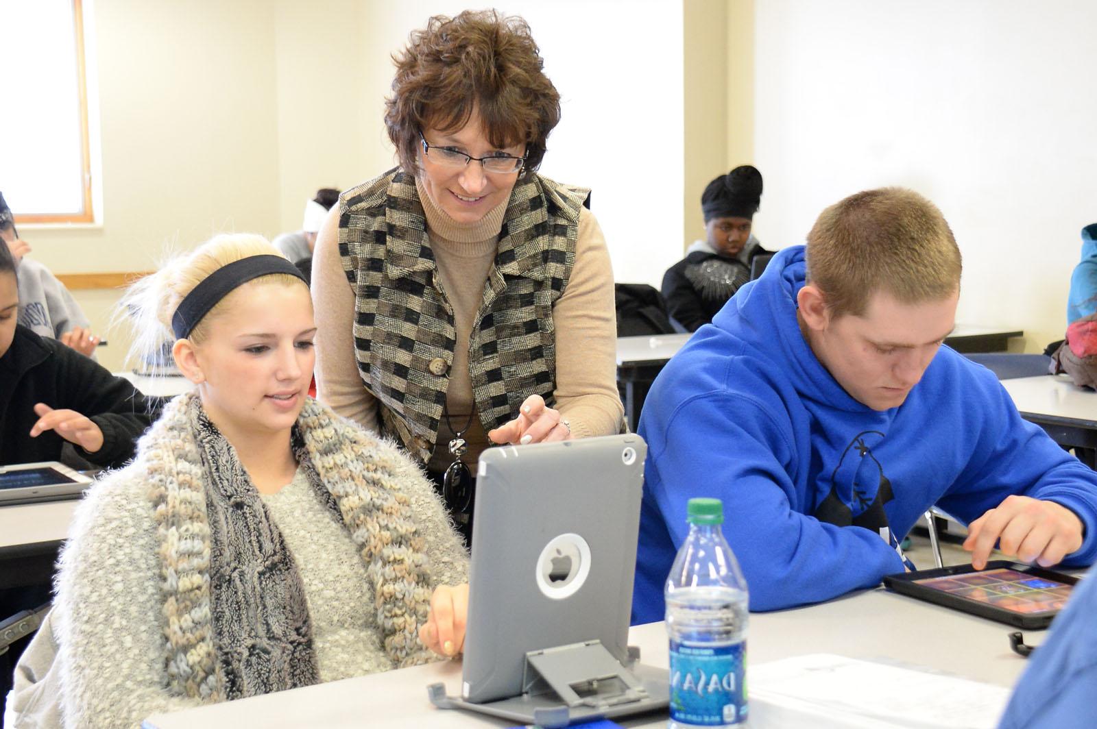 A female student showing her professor something on her tablet